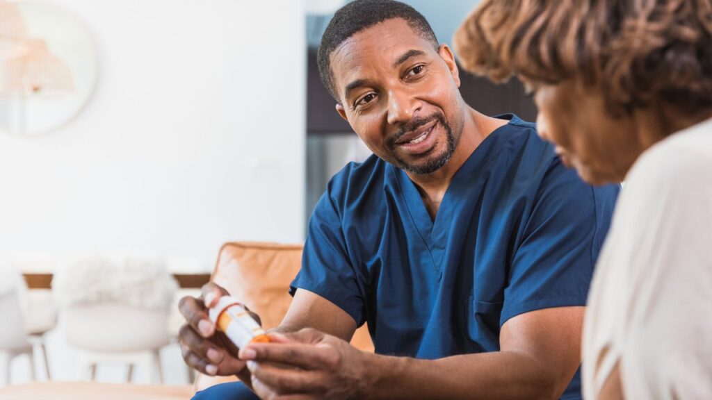 Male nurse discusses medications with a senior woman