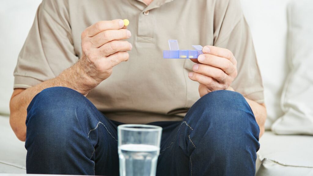 Seinor man holding medication in his hand