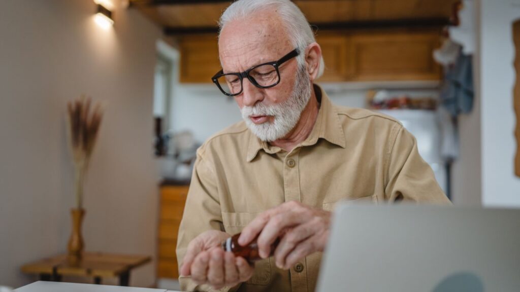 Senior man taking a drug tablet at home