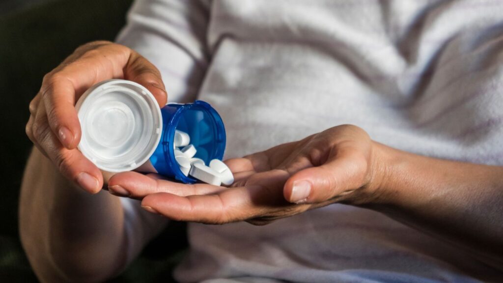 Senior woman taking pills from bottle