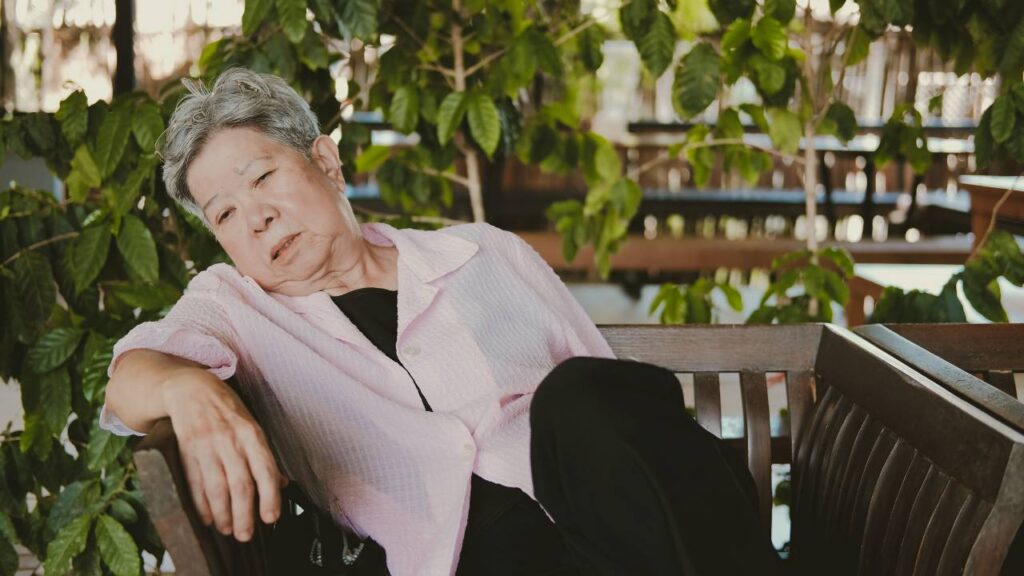 Sleepy Senior Woman sitting in garden