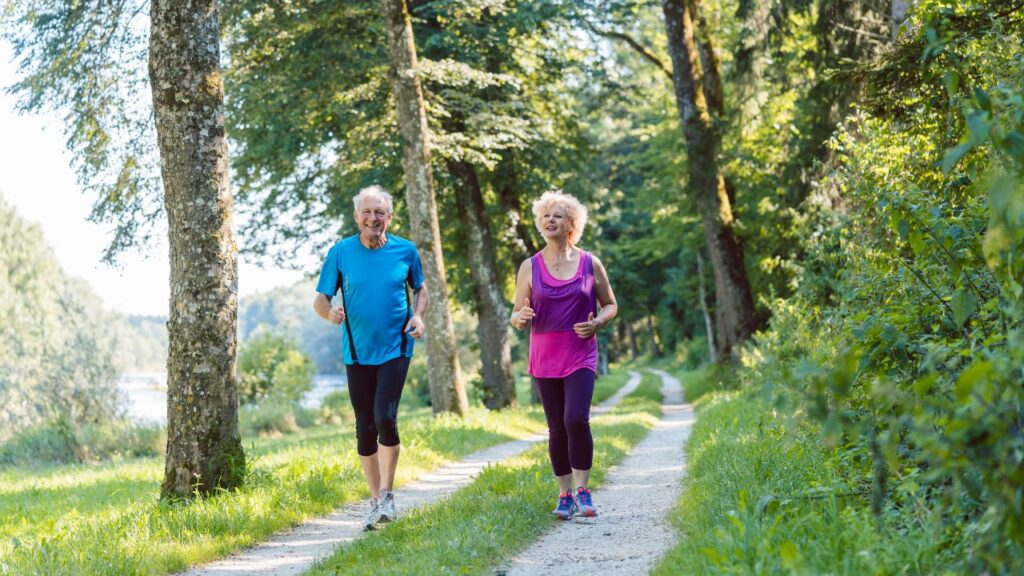 Two active senior jogging together in the park