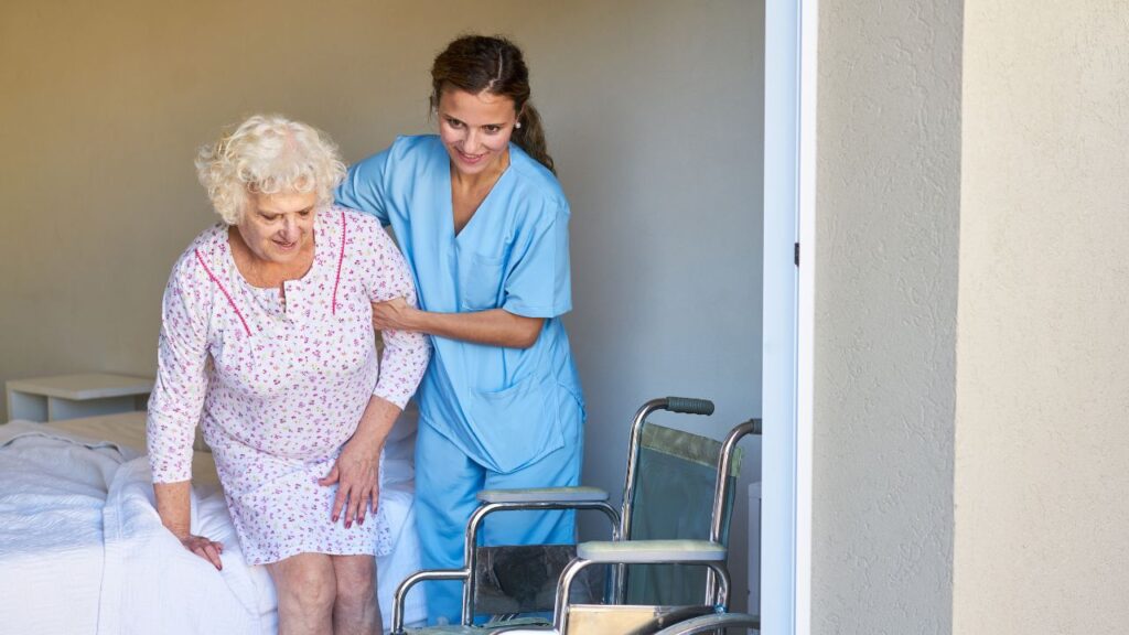 Nursing Aid Helps Senior Citizen to Get up in the Nursing Home