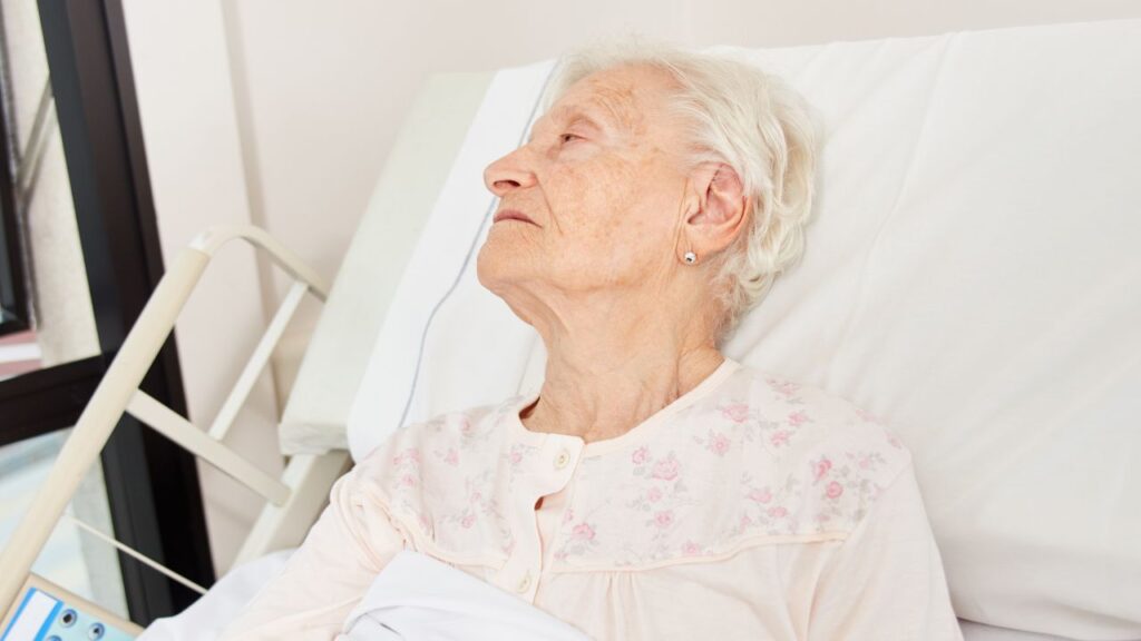 Senior Woman Lies Weak and Sick in Bed
