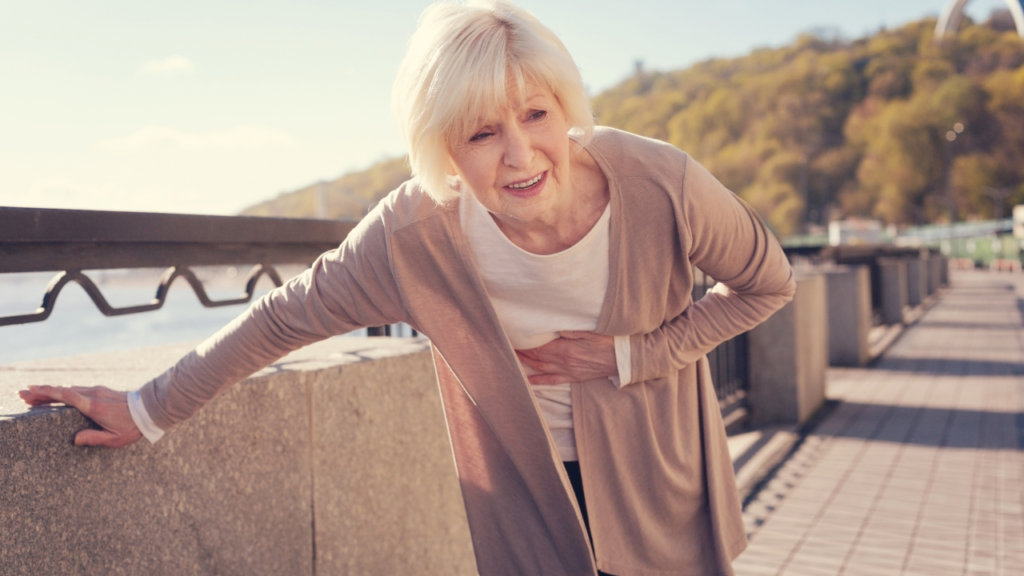 Senior woman writhing from severe abdominal pain