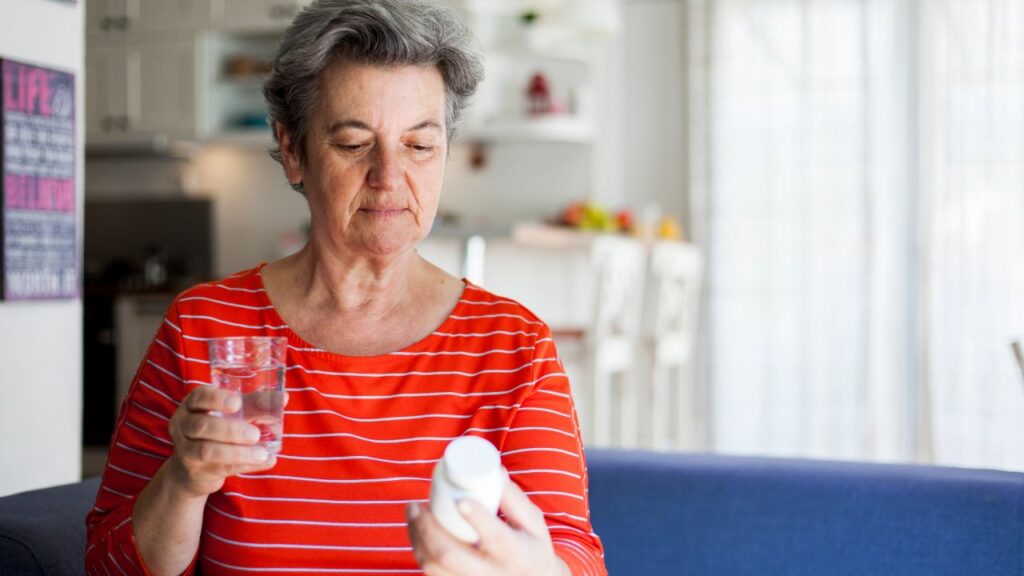 senior woman drinking pills