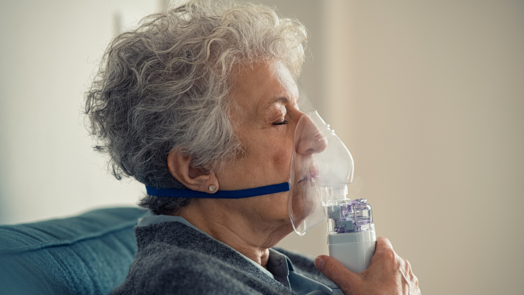 Sick Senior Woman Making Inhalation with Nebulizer